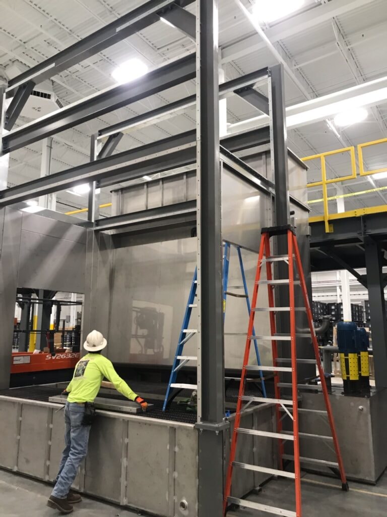 System construction — worker installing booth panels