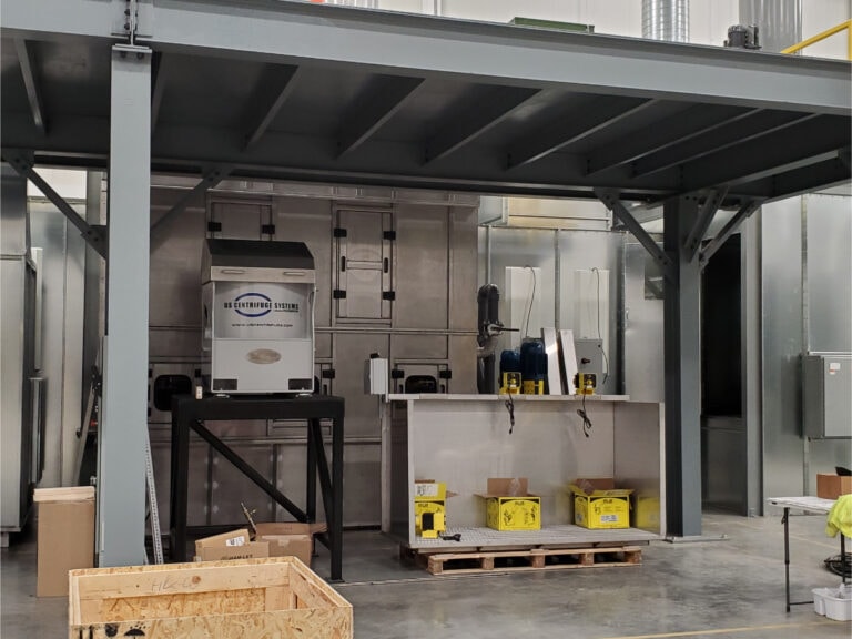 System construction — centrifuge and water wash components under mezzanine