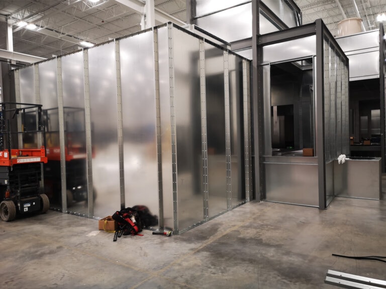 System construction — booth panels being assembled with scissor lift