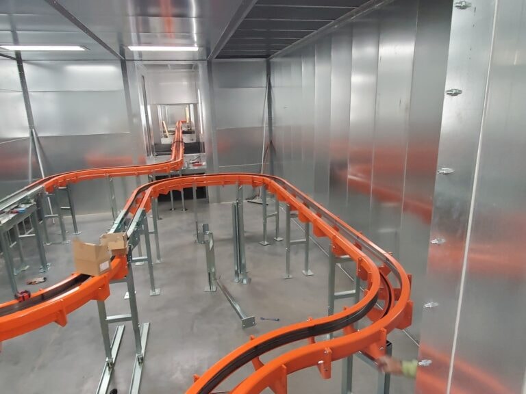 System construction — overhead conveyor loop inside booth interior