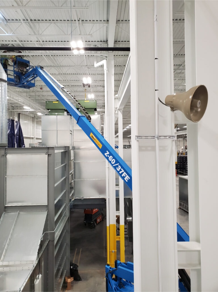 System construction — boom lift working on tall ductwork columns
