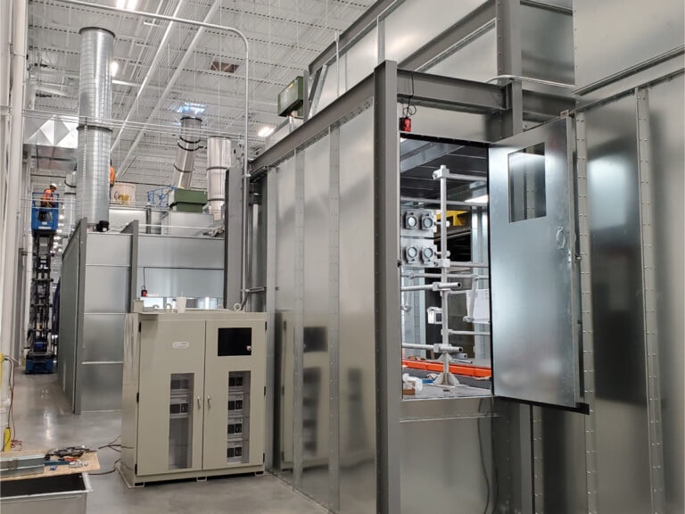System construction — spray booth exterior with UV system cabinet and open door