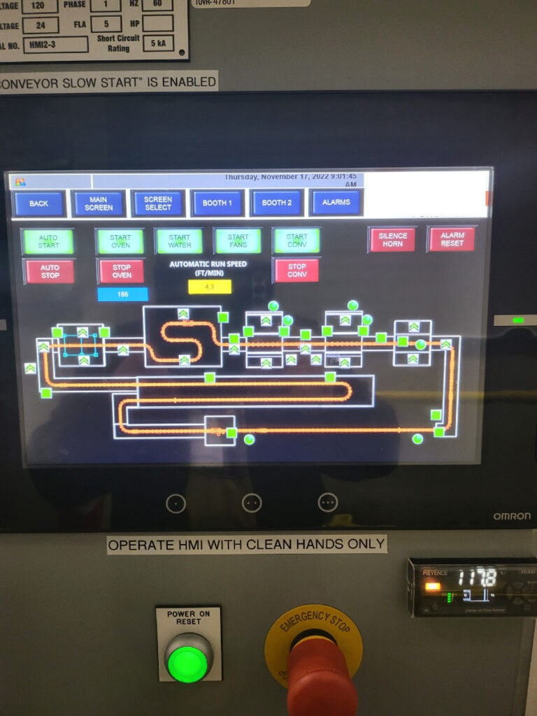 System construction — Omron HMI showing conveyor system layout with booth controls